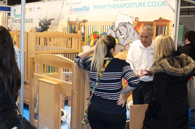 Customer talking to event stand staff about cots