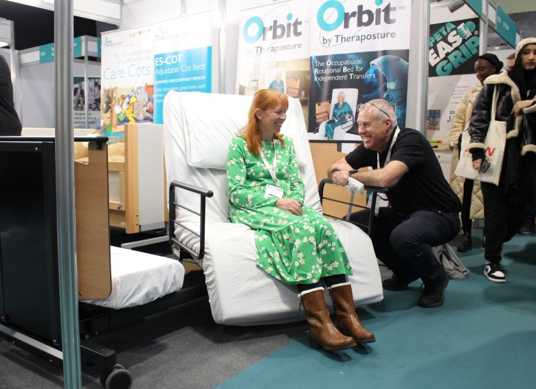 Woman trying out a Theraposture rotating bed at The OT Show